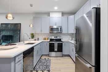 A modern kitchen with a refrigerator on the right side.